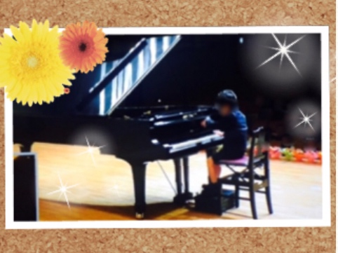 ピアノコンクールで演奏する7歳の男の子の写真