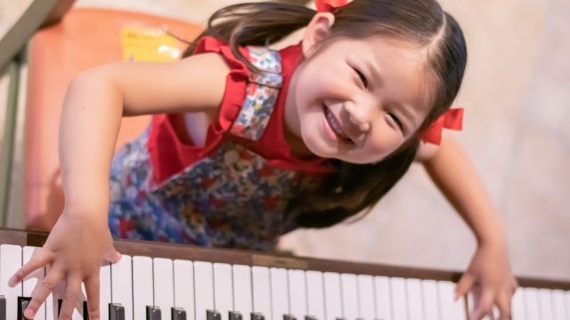 満面の笑みでピアノを弾く女の子の写真