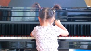 夢中になってピアノを弾く女の子の写真