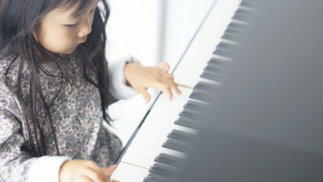 3歳の女の子がピアノを弾いている写真