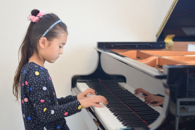 ピアノの練習をしている小学生の女の子の写真